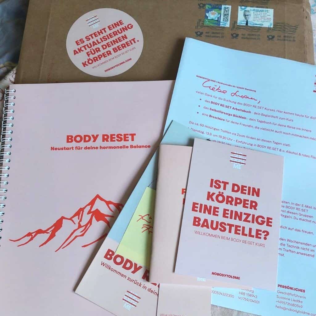 Unterlagen zum Body Reset Kurs von NOBODYTOLDME, ein Arbeitsbuch ein Brief ein Büchlein, ein Versandumschlag