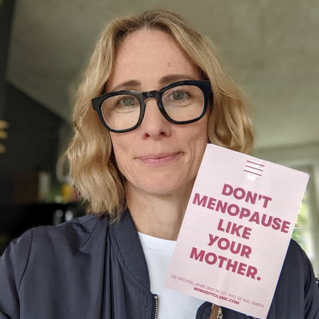 Susanne Liedtke hält ein Mini Poster in der Hand – Don’t menopause like your mother