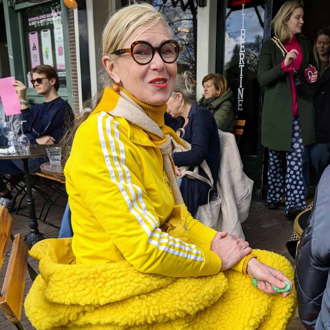Frau mit Hornbrille komplett in gelber Kleidung gekleidet, gesehen in Amsterdam