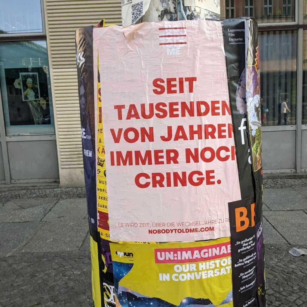 Straßen Laterne mit Poster in rosa und rotem Schriftzug
