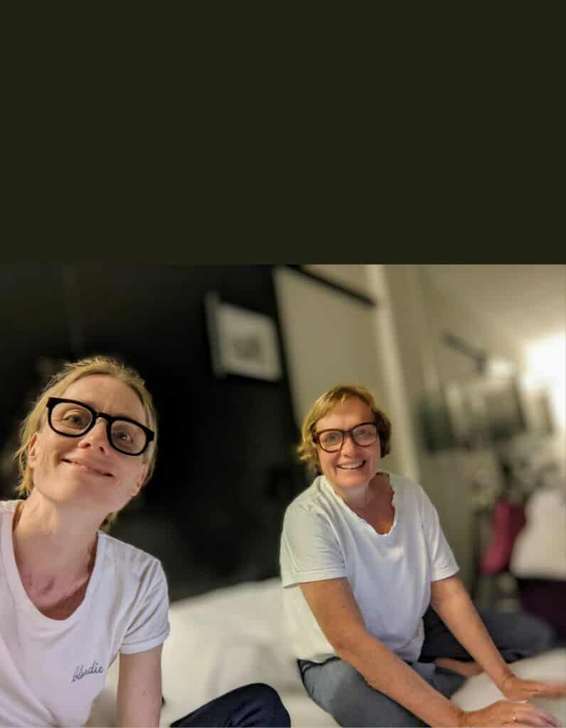 zwei Frauen in weißen T-Shirts lächeln in die Kamera