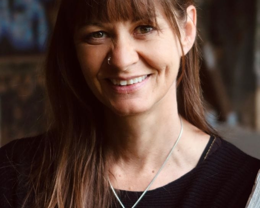 Frau mit Locken langen glatten braunen Haaren und Medaillon