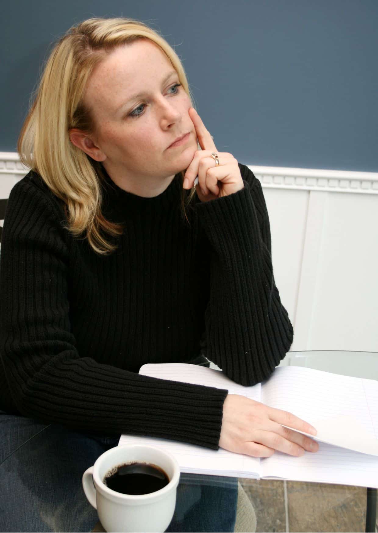 Eine Frau in schwarzer Kleidung ist dabei, einen Brief zu schreiben.