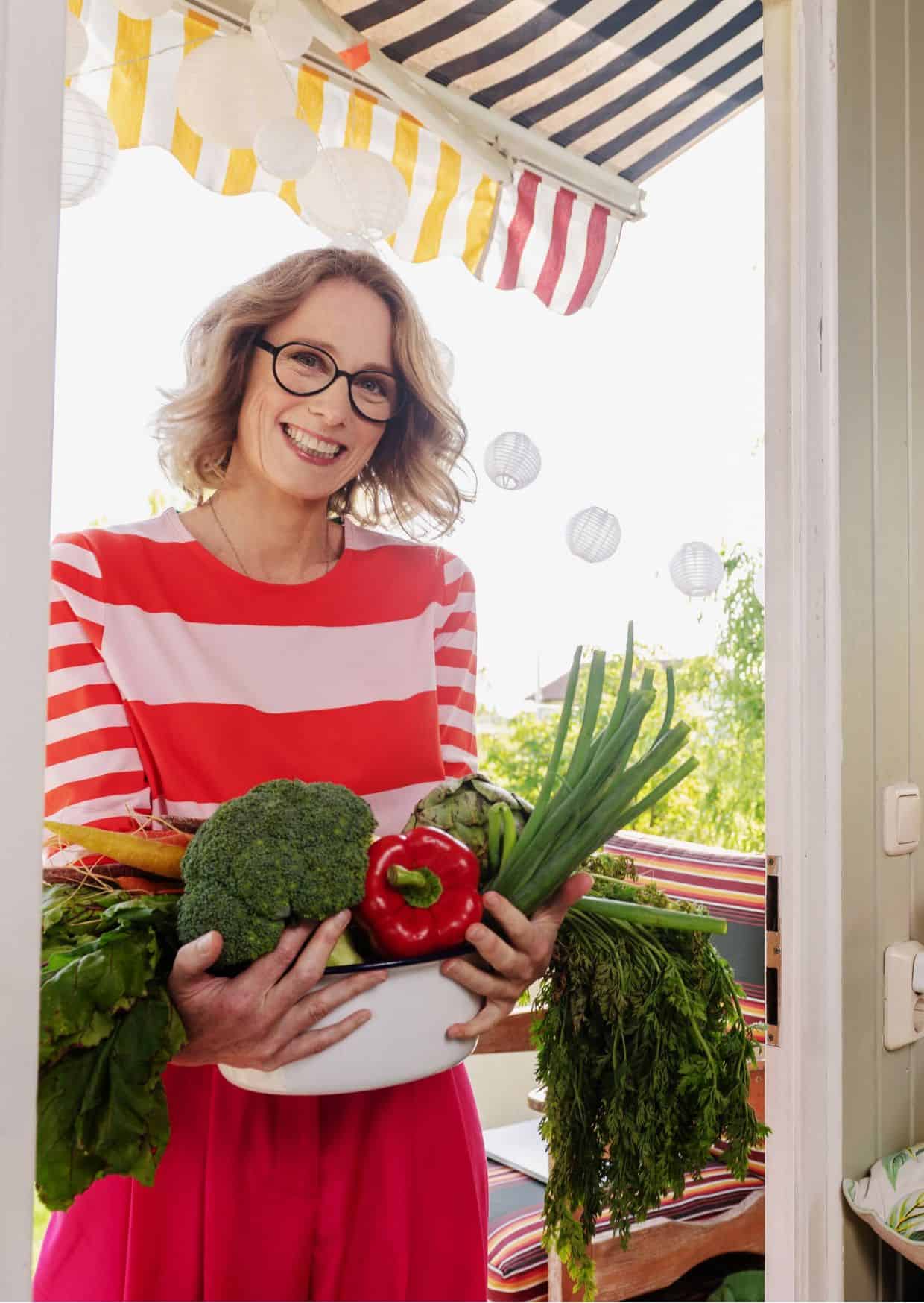 Susanne Liedtke hält Gemüse in einer rot-weiß gestreiften Bluse