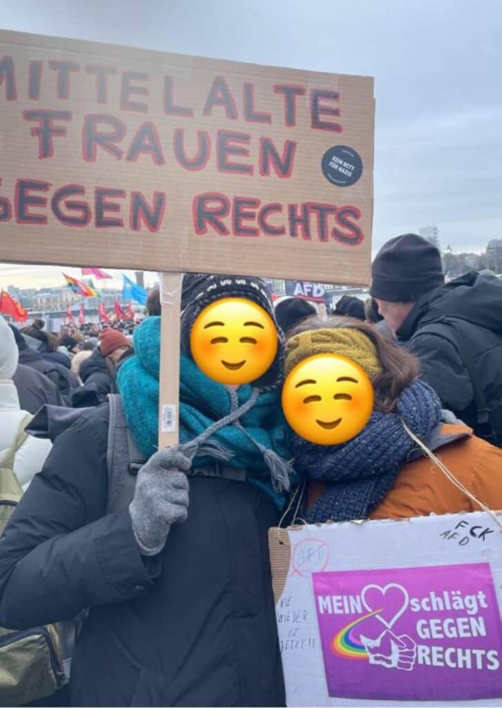 Zwei Personen mit Demonstration Schilder in der Hand und dicken Winter Klamotten