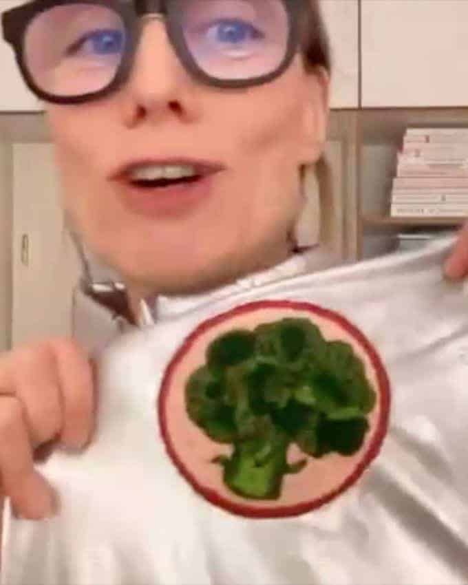 Frau mit silberfarbenem Anzug und Aufnäher eines Brokkolis.