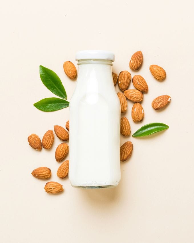 Flasche mit Milch auf ganzen Mandel platziert
