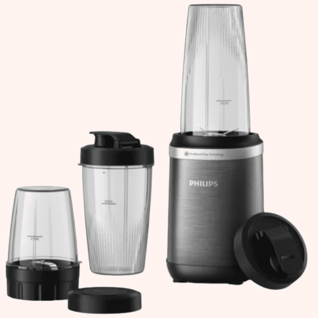 Standmixer Philips 5000 Series mit To-Go-Becher und kleinerem Mixbehälter daneben auf rosa Hintergrund