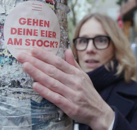 Susanne Liedtke klebt Sticker auf Laternenmast