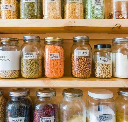 Regal mit Saaten und Nüssen in Vorratsgläsern