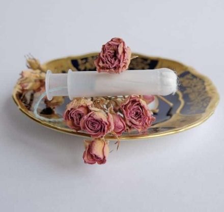 Getrocknete Rosen auf einer gold-randigen Schale mit einem Tampon in der Mitte