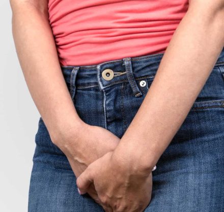 Blasenschwäche, Frau hält beide Hände schützend im Schritt