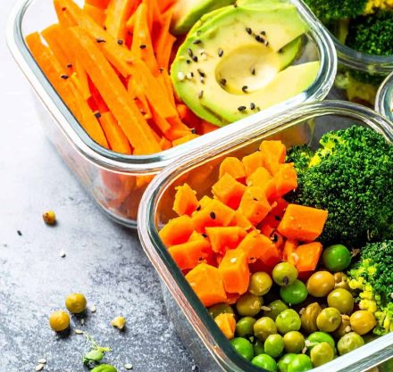 Bunte gesunde Mahlzeit mit Avocado, Karotten, Brokkoli, Erbsen und Süßkartoffeln in Glasbehältern – frische, ballaststoffreiche Ernährung für mehr Energie und Wohlbefinden.