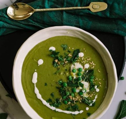 Cannellini-Suppe in einem Teller von oben. Ein grünes Tuch liegt neben dem Teller, und ein goldener Löffel