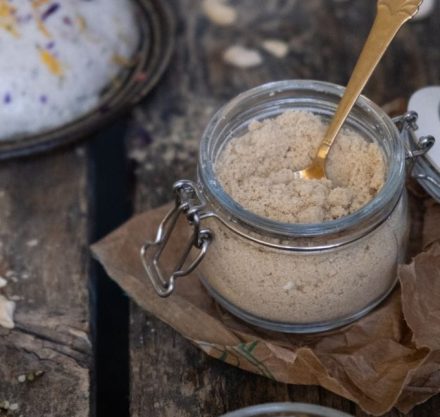 Einmachglas mit goldenem Löffel gefüllt mit veganem Parmesan. Schüssel mit Hanfsamen-Cashew-Käse. Alles garniert mit Blüten Raspeln.