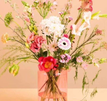 Blumenstrauß mit bunten Blumen in einer klaren rosa Vase