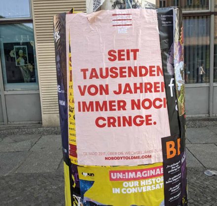 Straßen Laterne mit Poster in rosa und rotem Schriftzug