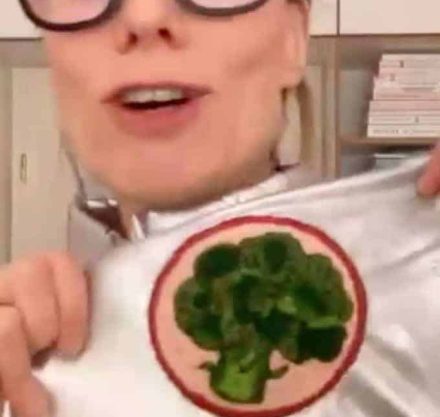 Frau mit silberfarbenem Anzug und Aufnäher eines Brokkolis.