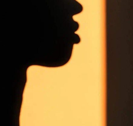 Shadowy outline of a women's face in yellow light