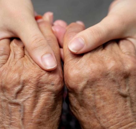 Die beiden Hände Tochter hält die Hände ihrer pflegebedürftigen Mutter