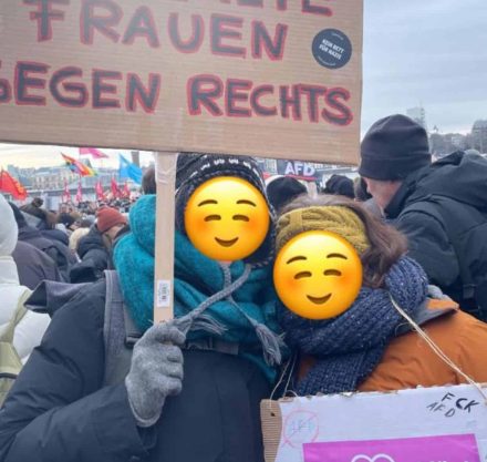 Zwei Personen mit Demonstration Schilder in der Hand und dicken Winter Klamotten